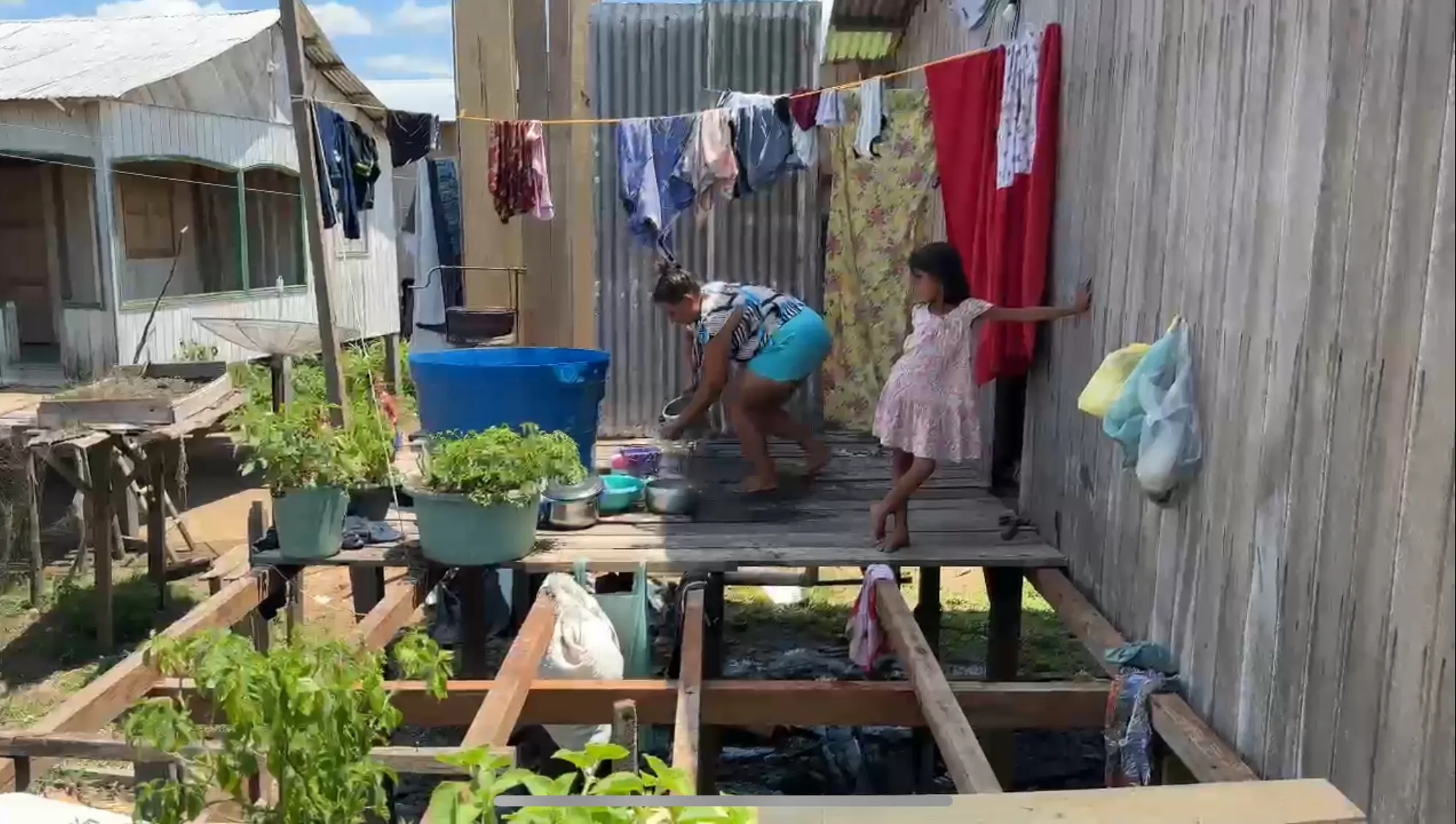 Ribeirinha lavando a louça no mesmo espaço utilizado para o banho. Foto: Elias Nogueira