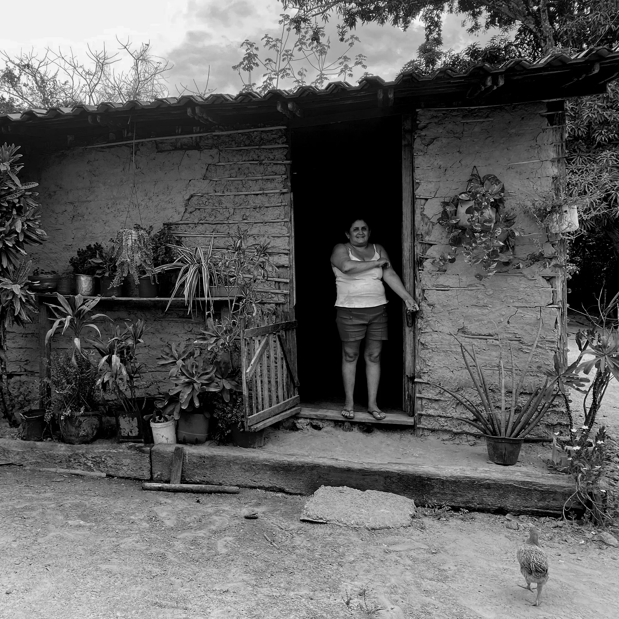 Foto preto e branco de moradora em casa de barro. Foto: Adriana Menezes