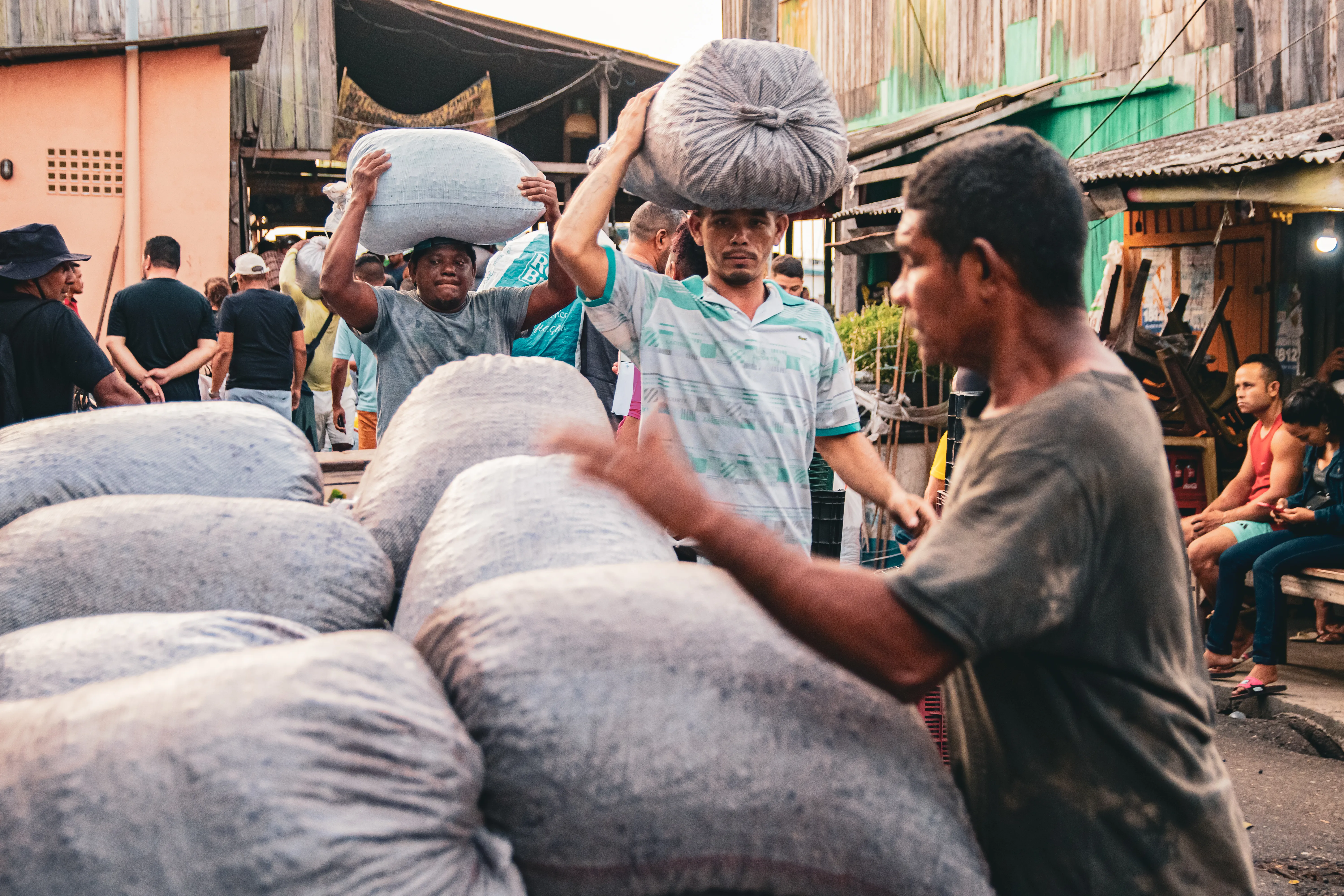Carregadores levando as sacas de açaí comercializadas para os carros dos compradores. Foto: Harrison Lopes