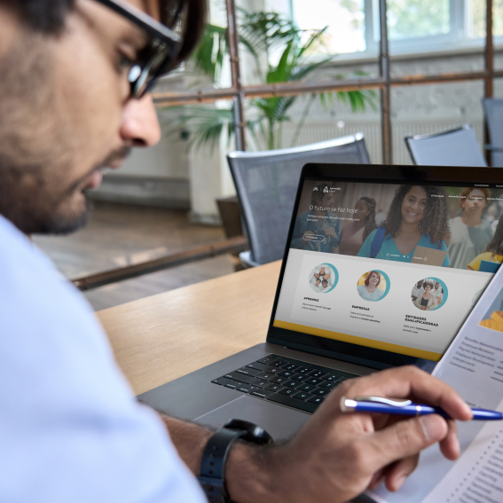 Jovem com um currículo na mão e um laptop