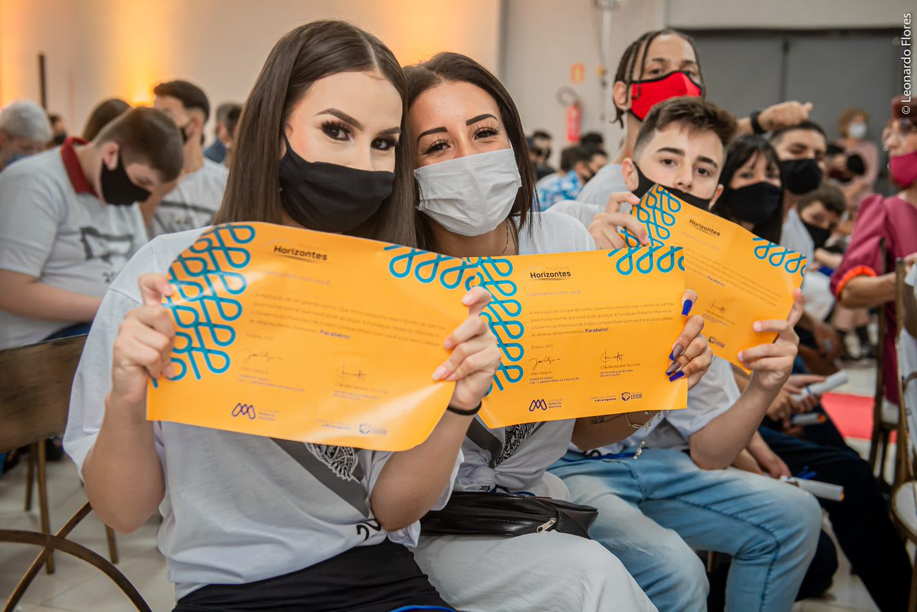 duas alunas e um aluno mostrando seus diplomas em cerimônia de formatura do projeto Horizontes em Esteio no RS