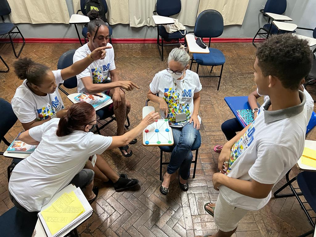 cinco estudantes da Unidade Escolar FRM fazendo uma atividade em grupo