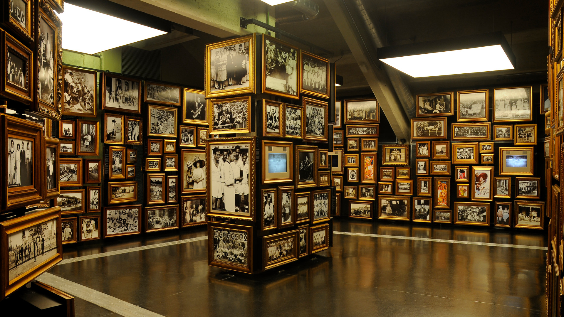 Sala com diversas fotografias de referências futebolísticas espalhadas por paredes e pilastras.