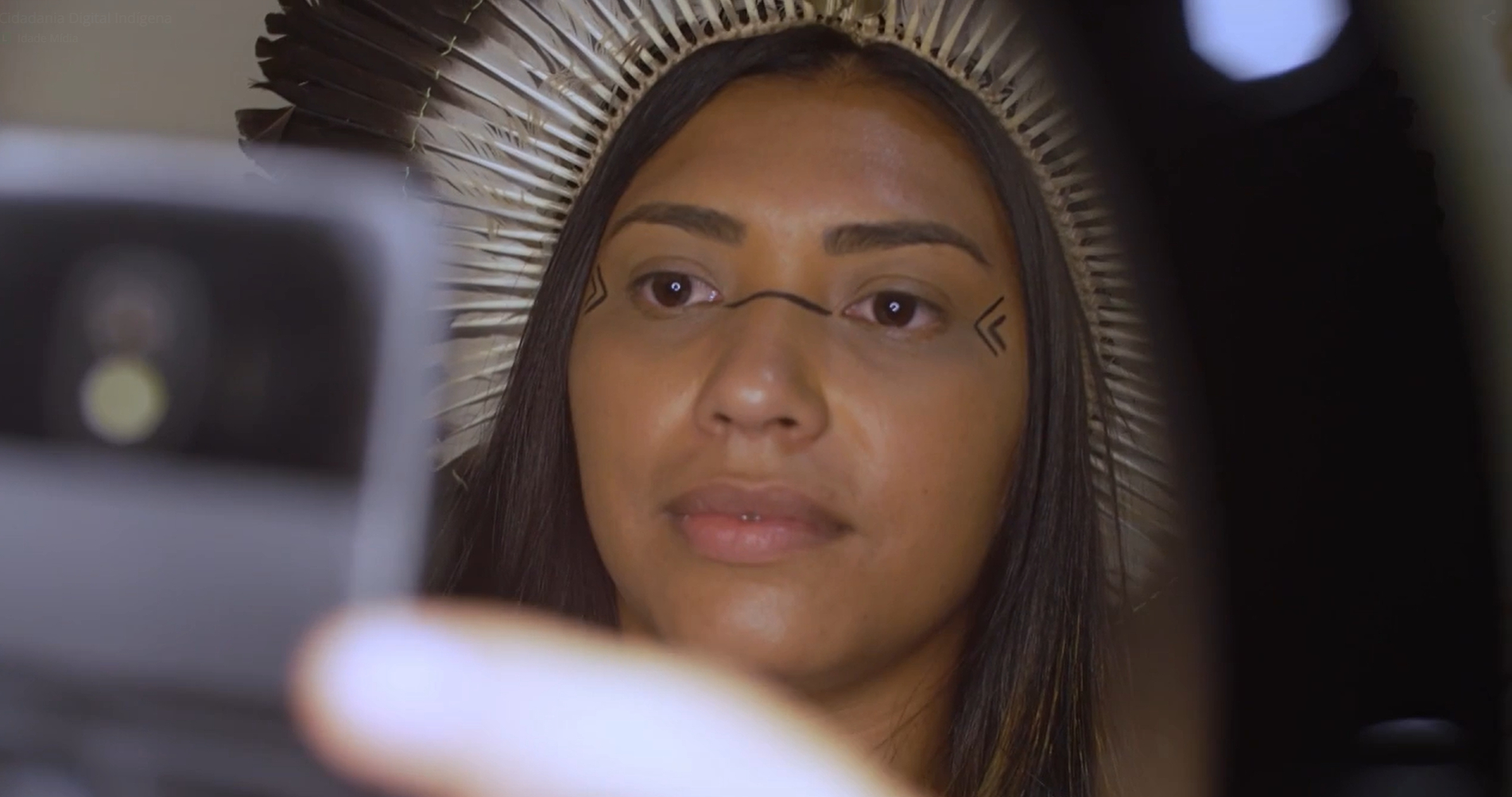 Uma mulher negra olhando para a tela de um celular