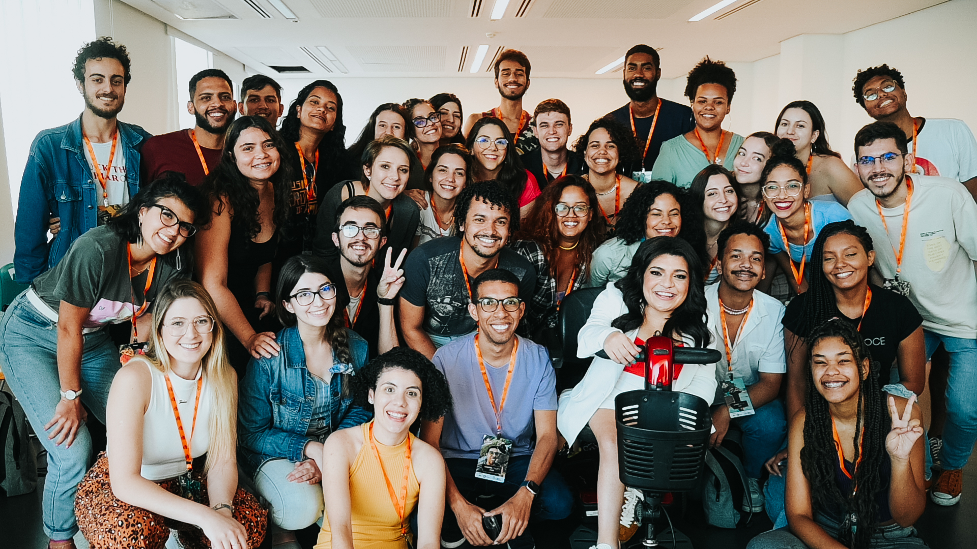 Um grupo com diversos estudantes posando para foto em uma sala de aula