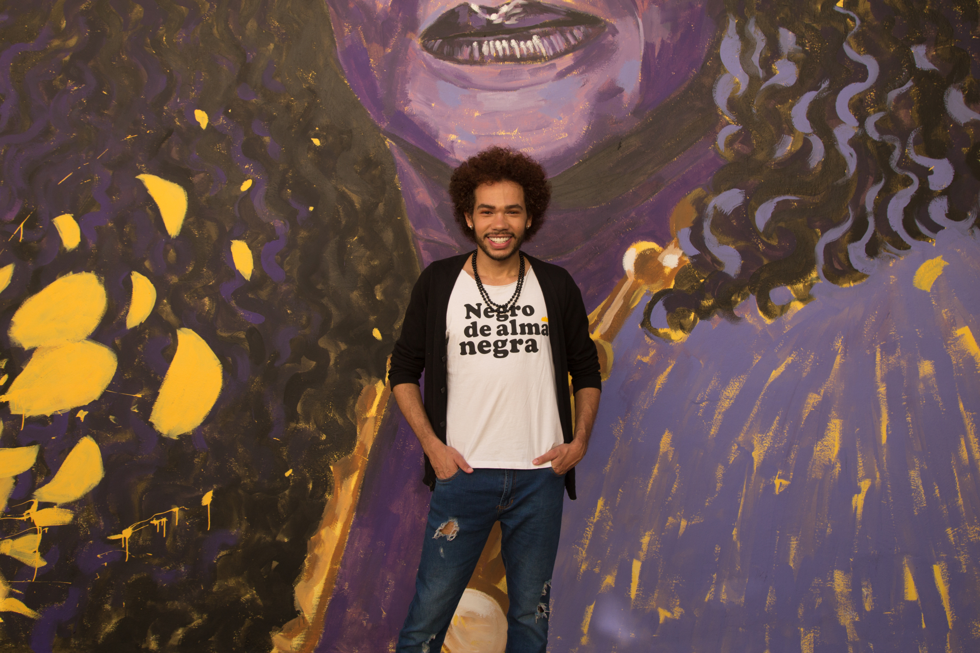 Um jovem negro em frente a um mural