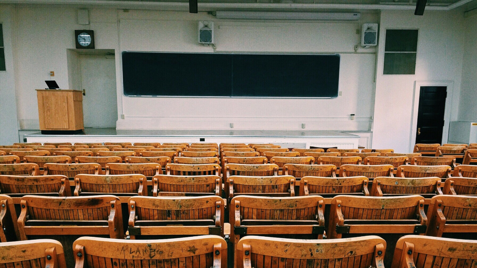 Uma sala de aula com todos os assentos vazios.