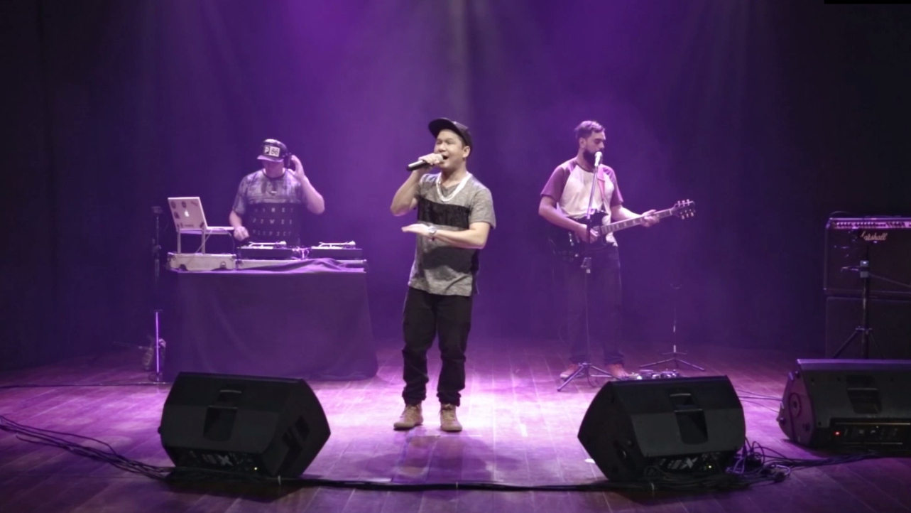 A imagem mostra 3 homens em um palco