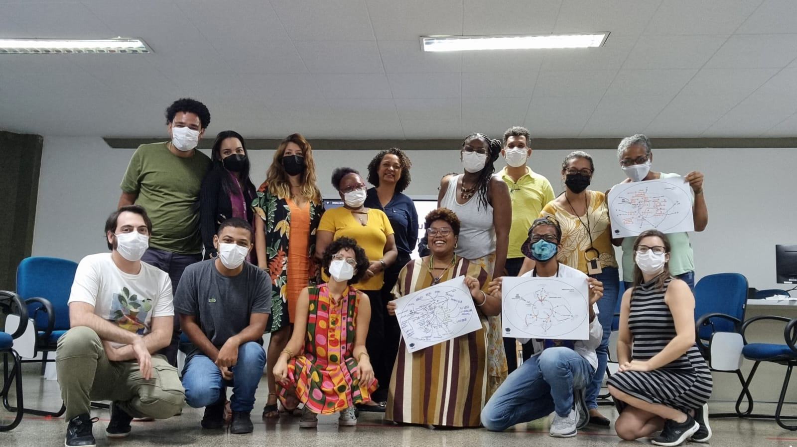 A imagem mostra um grupo de pessoas em uma sala de aula