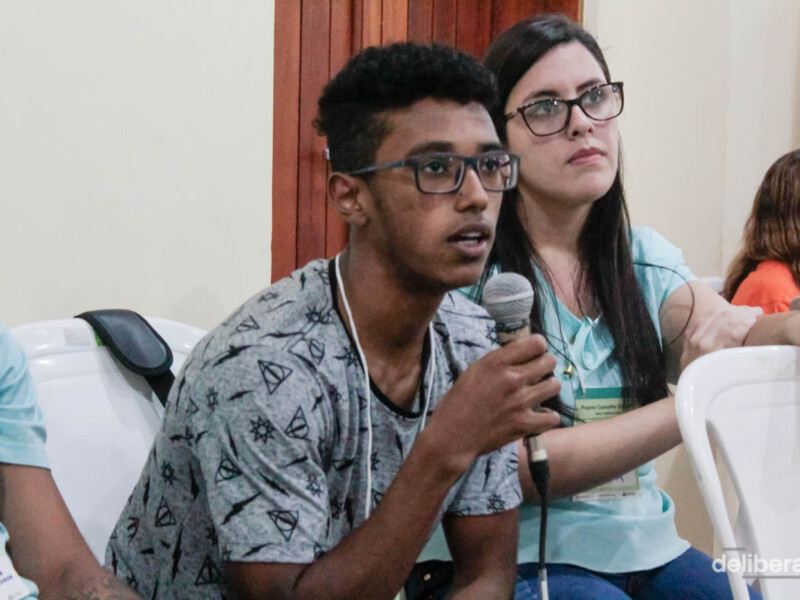 Um rapaz fala ao microfone