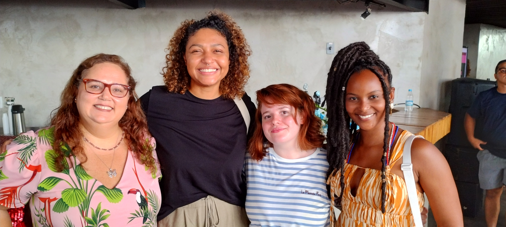 Quatro mulheres sorriem.