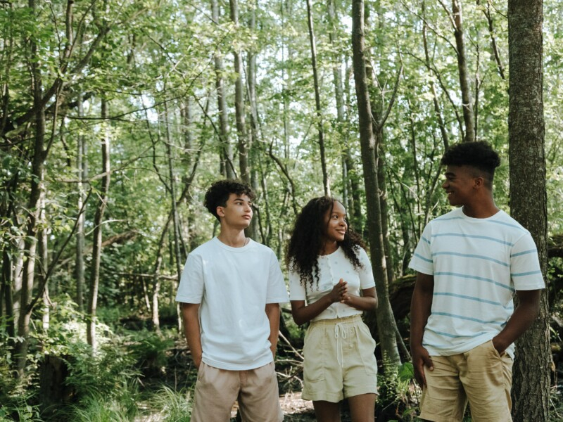 Três jovens em uma floresta