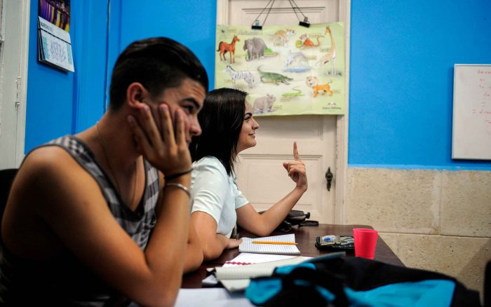 Dois jovens em sala de aula, um menino e uma menina