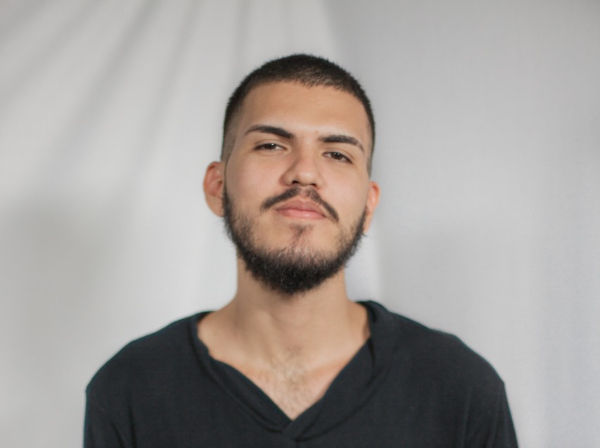 A foto de Elias, um rapaz jovem, branco, de barba rala e cabelo bem baixinho, raspado nas laterais