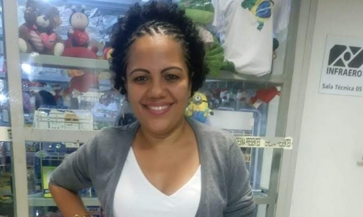 Imagem da professora Juliana, uma mulher negra, de tranças escuras e bem sorridente