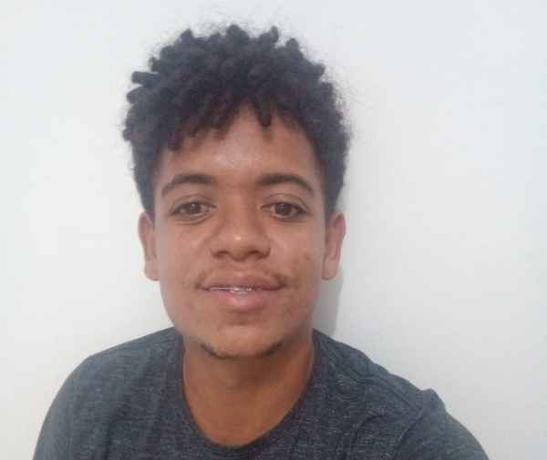 Foto de Roberto, um rapaz negro de cabelo com várias pequenas trancinhas e bigode falhado, como se ainda estivesse crescendo