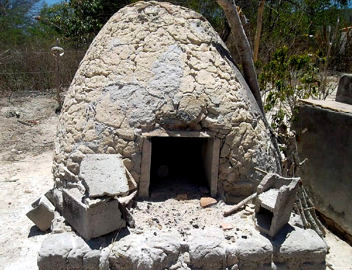 Uma pequena oca de pedra com uma portinhola em que só daria para alguém entrar se estivesse engatinhando