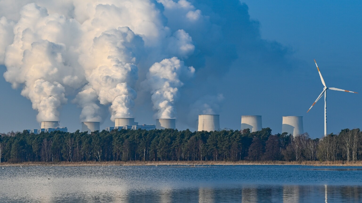 Imagem do que parece ser uma usina nuclear com várias torres soltando fumaça para o meio ambiente