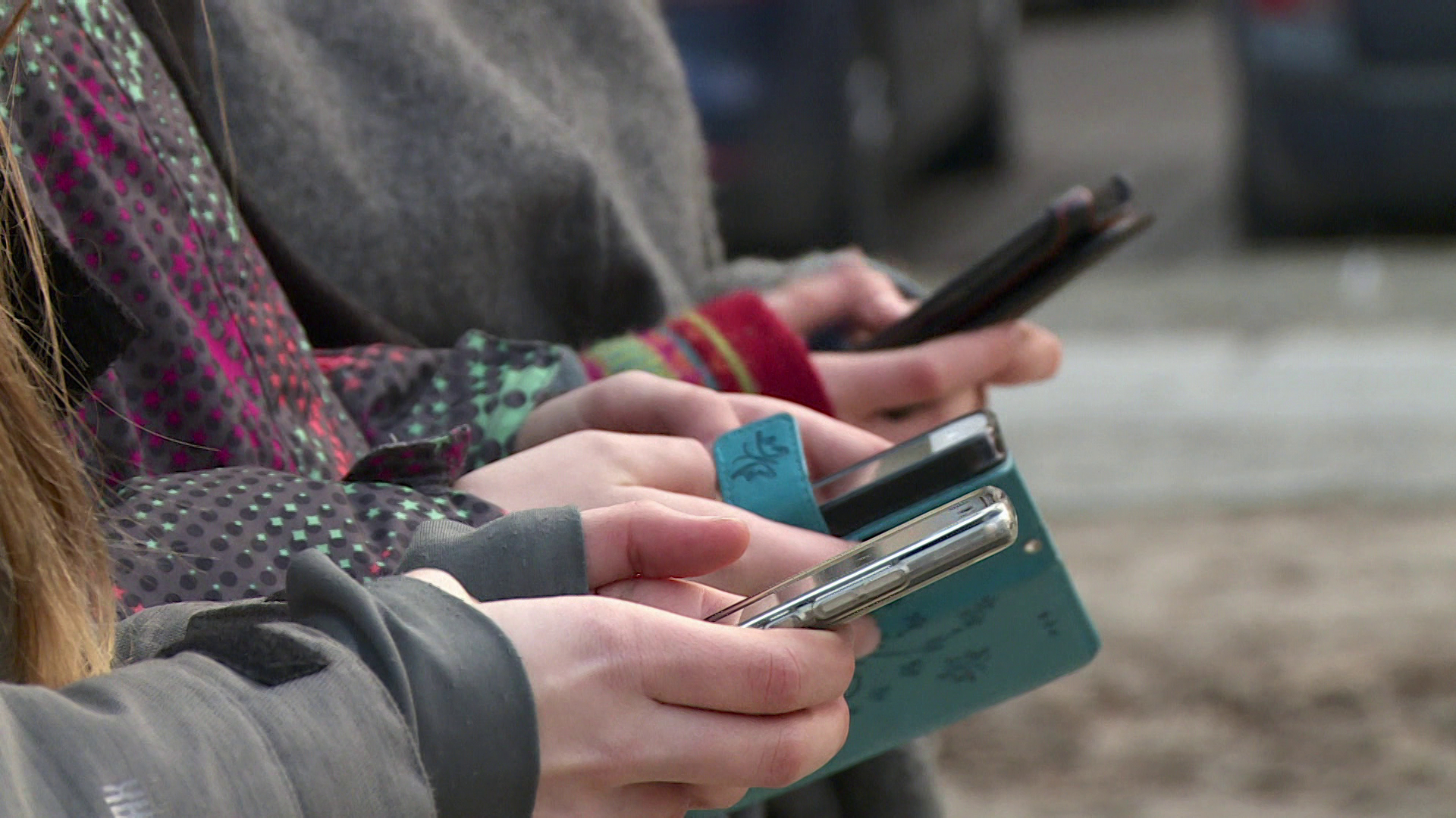 Pessoas estão lado a lado, mas a imagem só capta suas mãos, que estão segurando celulares.