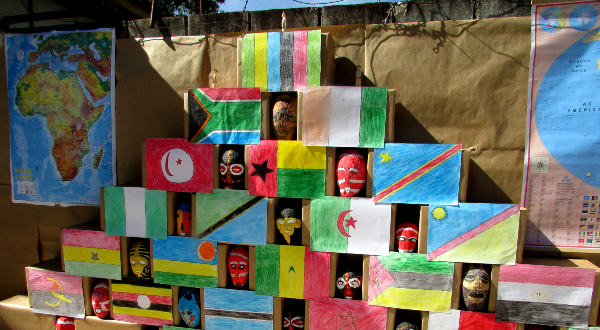 Imagem de várias bandeiras de países africanos, máscaras típicas da cultura africana e um mapa do continente
