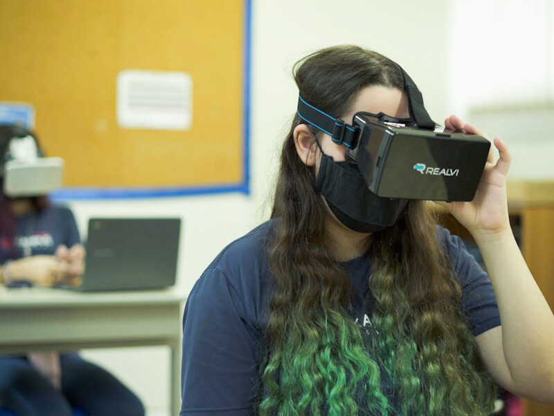 Uma menina está usando óculos de realidade virtual