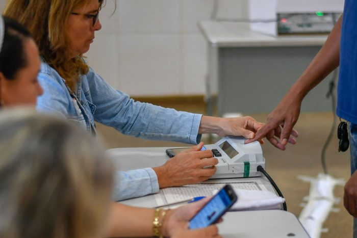 Imagem de uma mulher na mesa de apuração de votos
