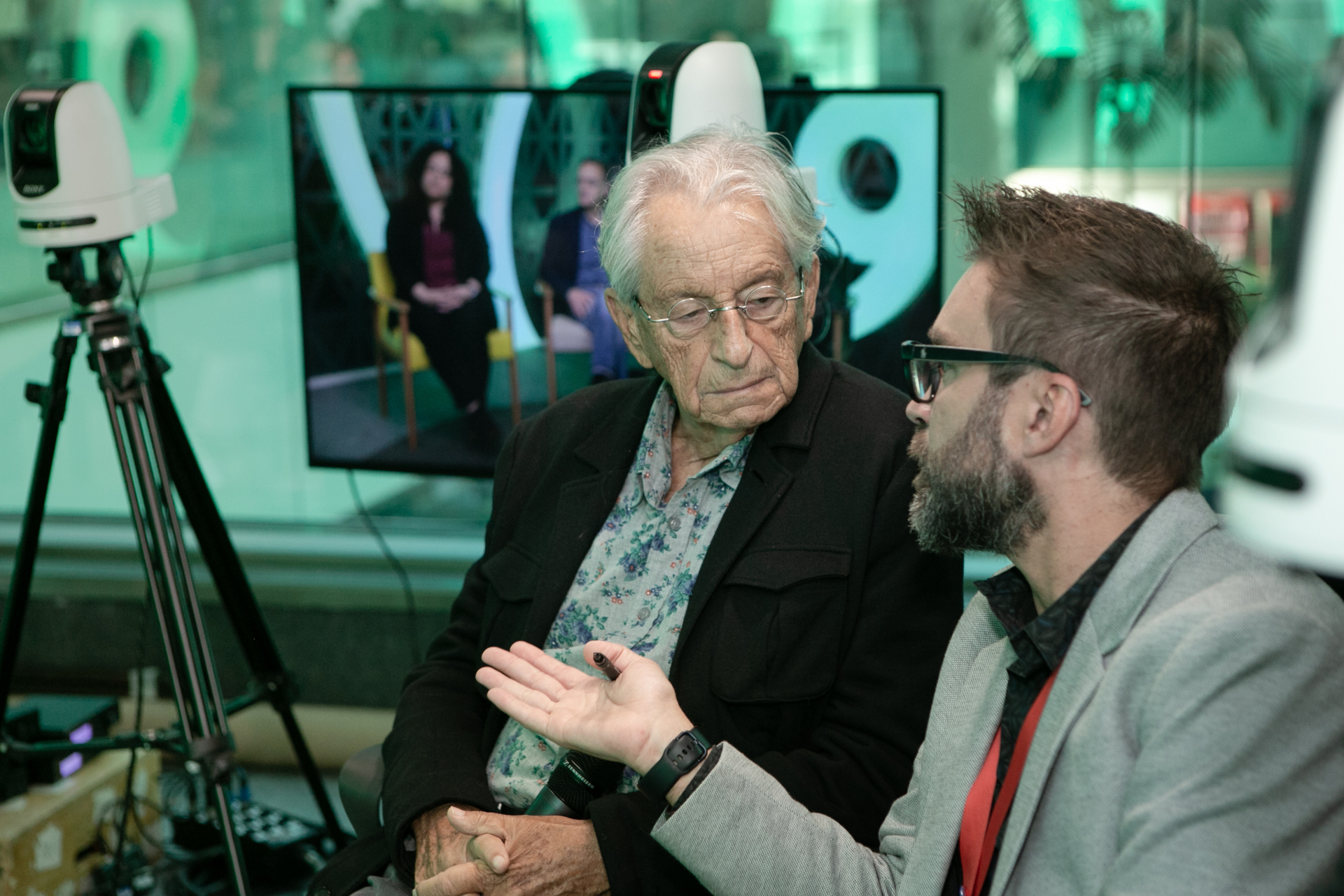 Dois homens conversam em uma sala com o fundo em verde-claro. À esquerda, o jornalista Fernando Gabeira. À direita, José Brito, gerente do Canal Futura.