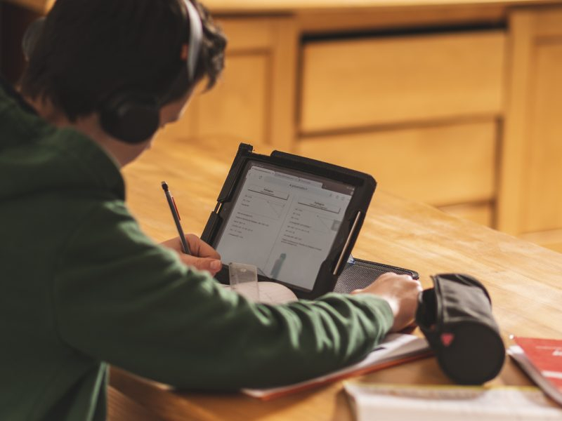 Um jovem rapaz está estudando diante de um notebook aberto