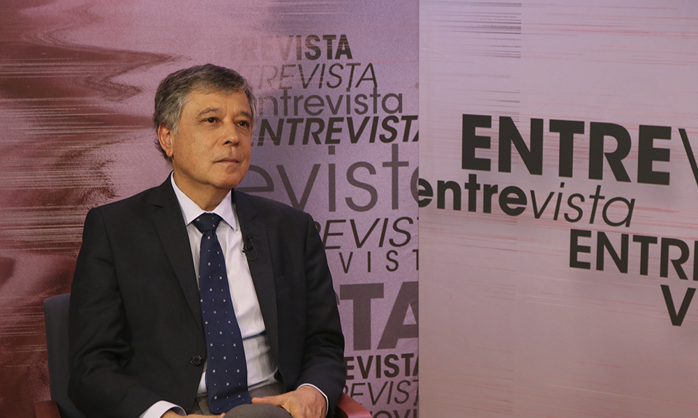 Imagem de Chico Soares, um homem com alguns cabelos grisalhos, sentado no estúdio do Entrevista e trajando terno e gravata