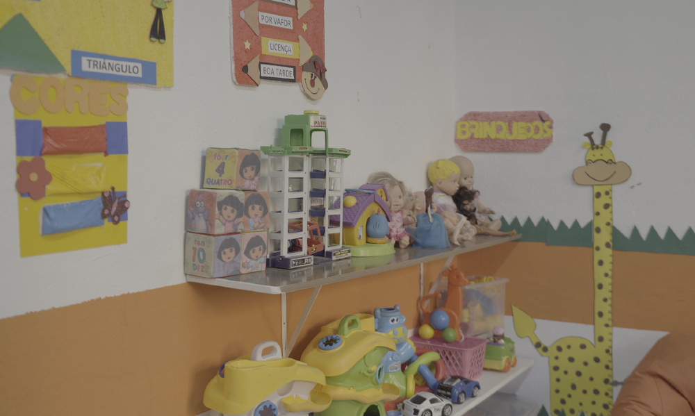 Brinquedos de crianças estão organizados em prateleiras em um canto colorido