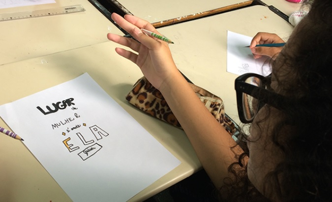 Desenho de uma menina em uma folha branca com os dizeres "Lugar de mulher é onde ela quiser"
