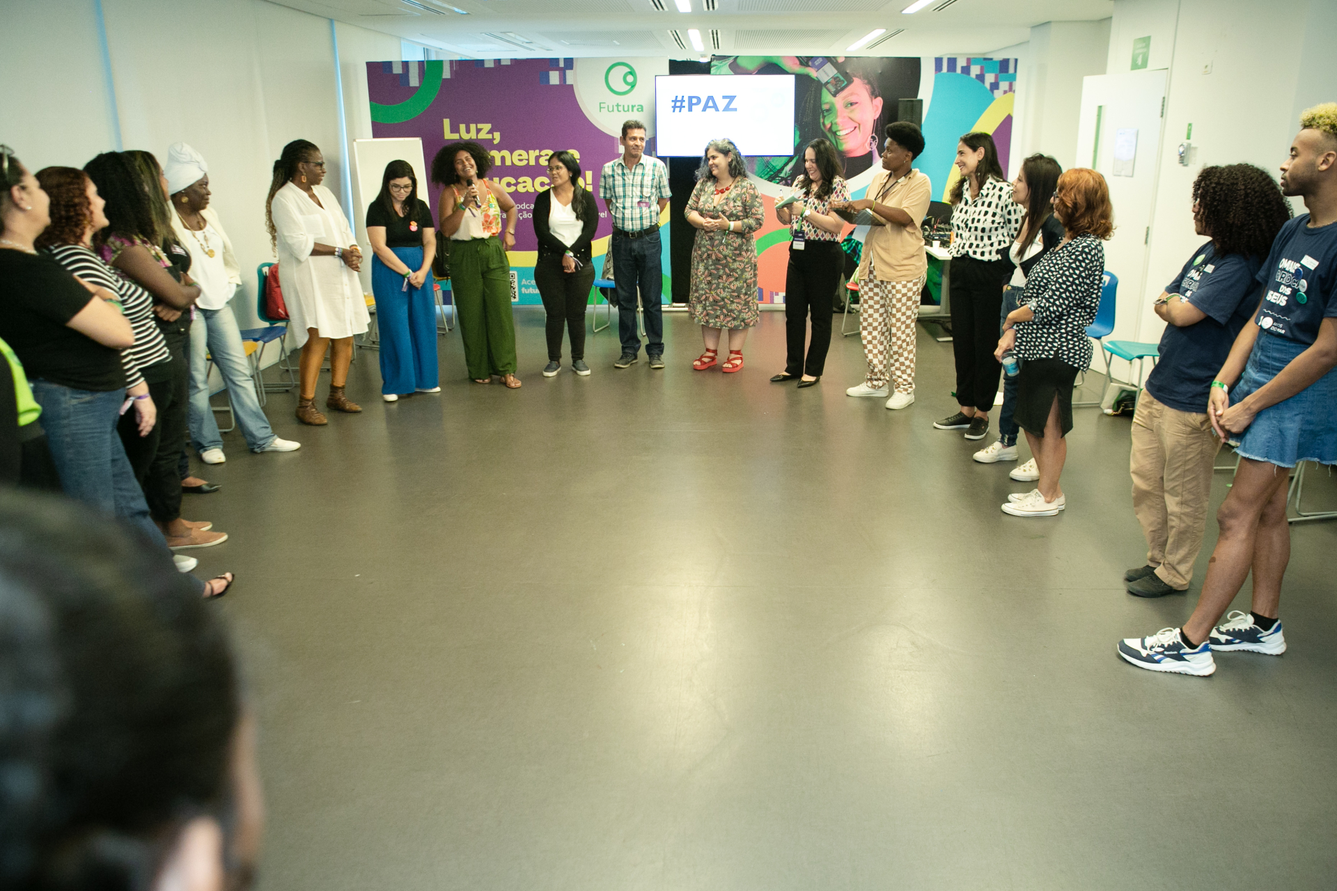 Diversas pessoas organizadas em U, em uma sala.