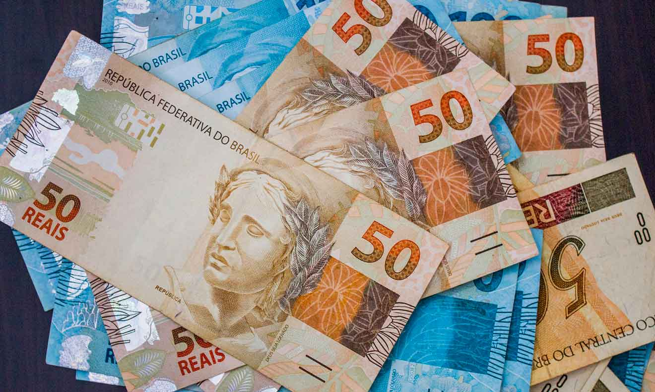 Várias cédulas de 50 e de 100 reais amontoadas