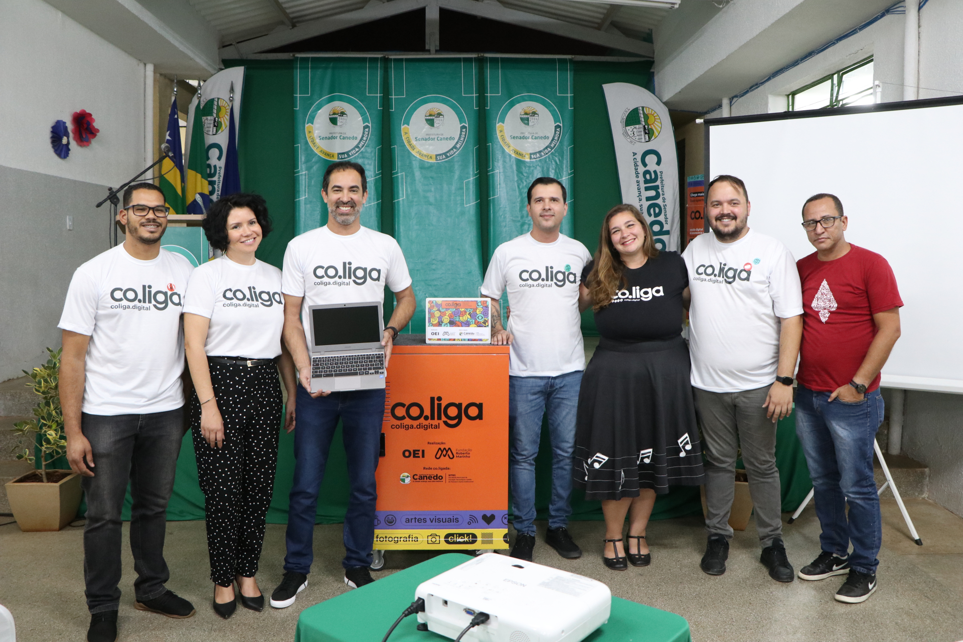 Homens e mulheres com camisa da co.liga posam para foto