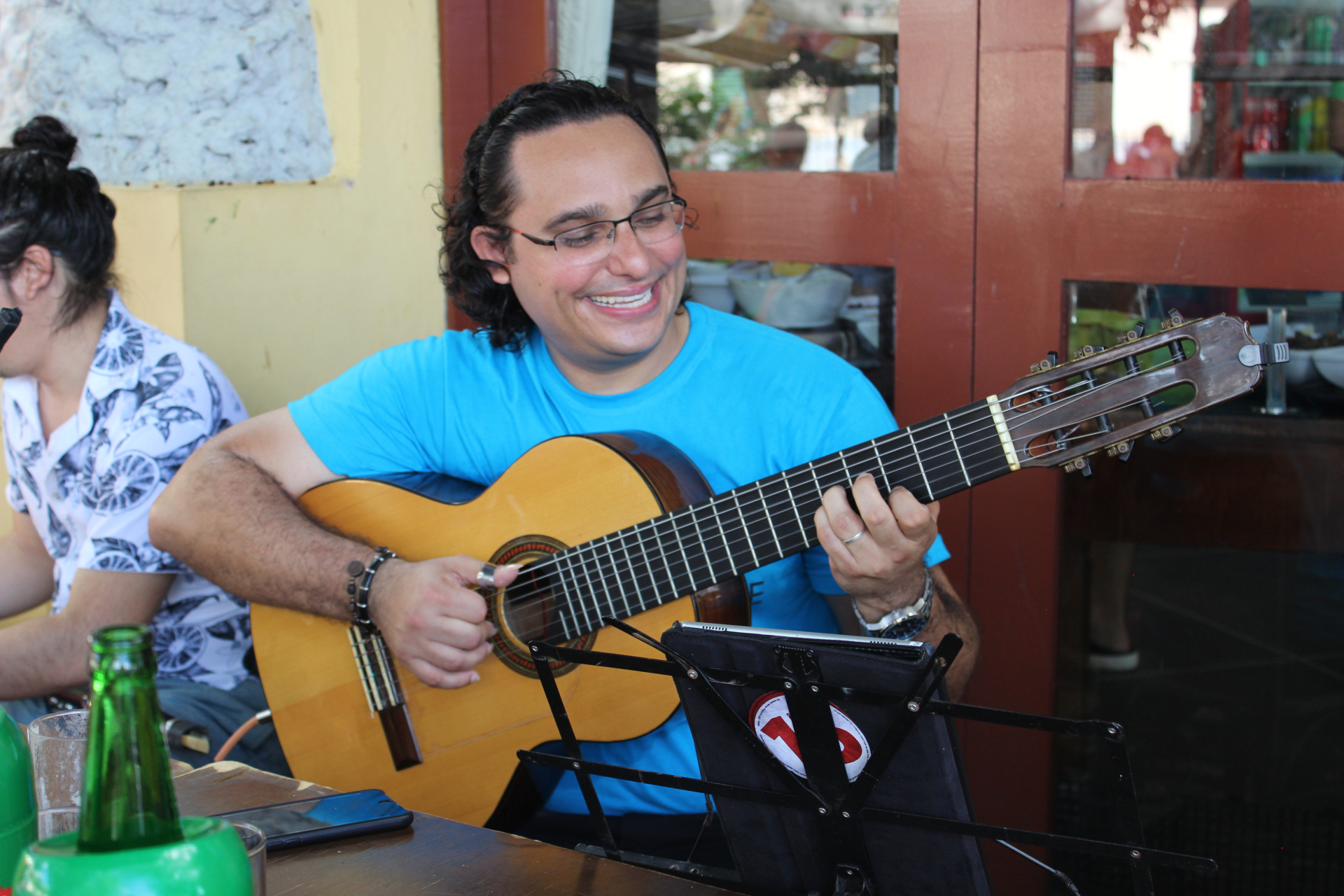 A imagem mostra um homem tocando um violão.
