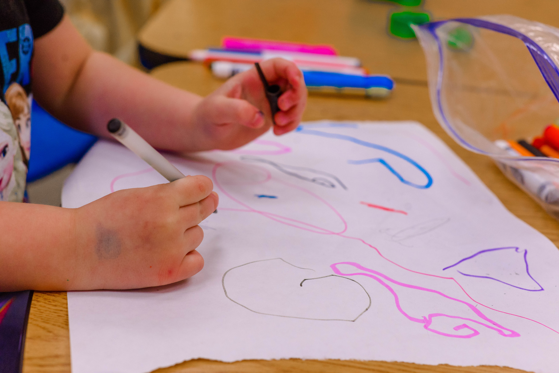 Uma criança desenhando em um papel em uma escola