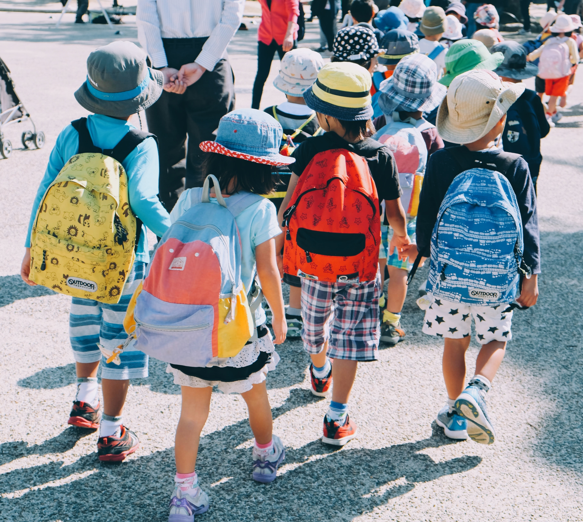 Crianças com mochilas nas costas e andando em grupo