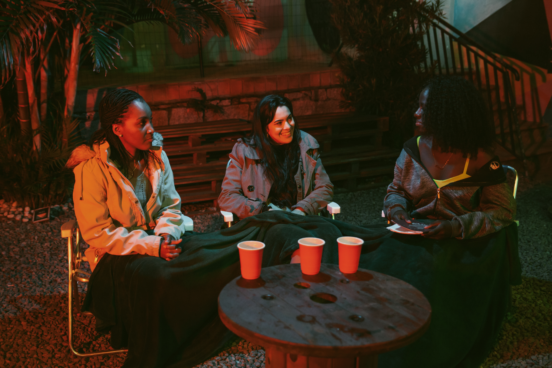 A imagem mostra 3 mulheres sentadas conversando