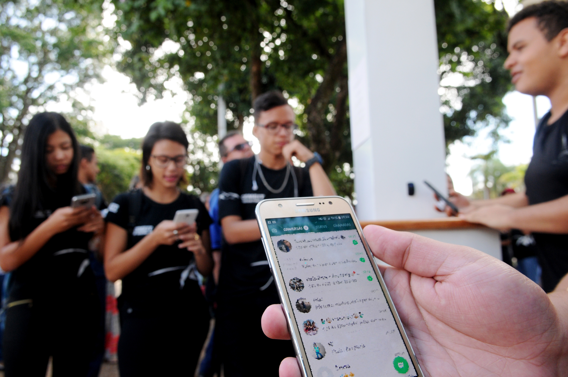 Adolescente mexendo no celular em uma escola