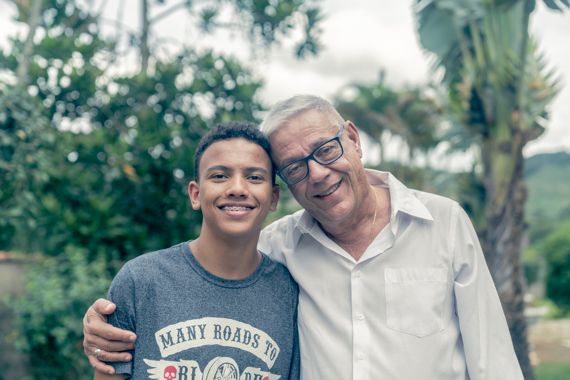 A imagem mostra um homem idoso e um jovem lado a lado