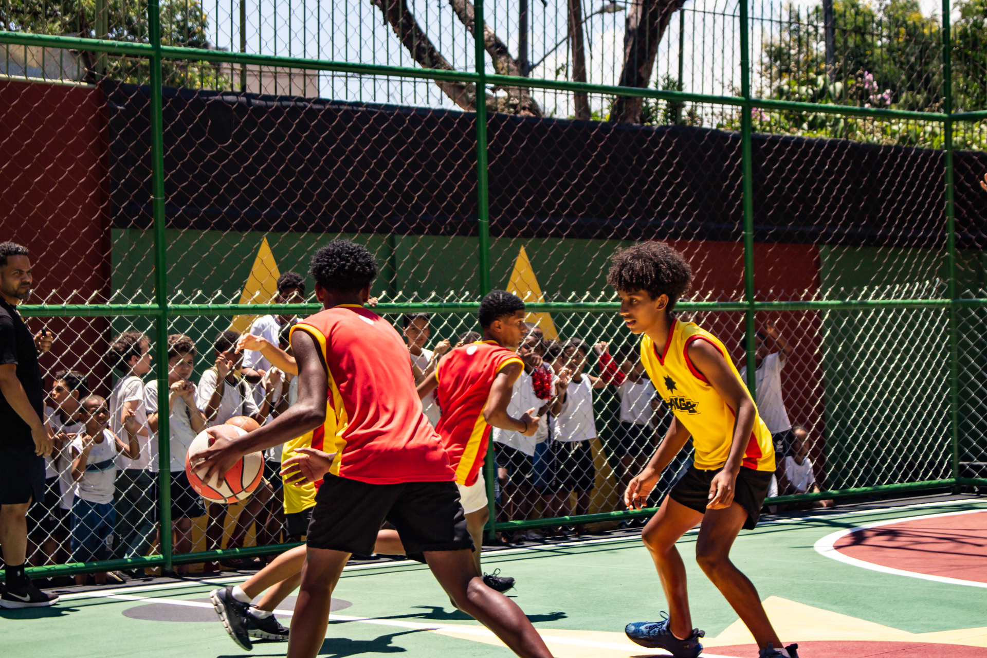 Meninos jogam basquete.
