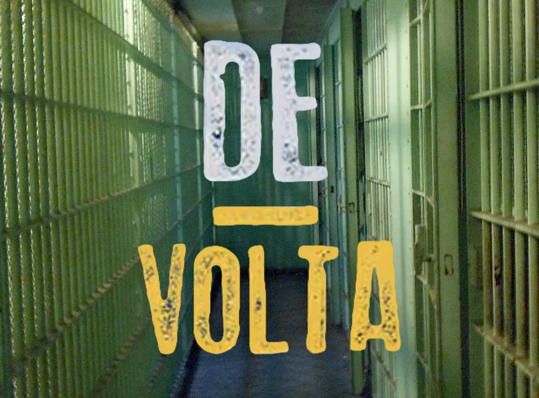 O nome do filme "De volta" está escrito sobre uma fotografia de um corredor de um presídio. Há celas em perspectiva, à direita e à esquerda.