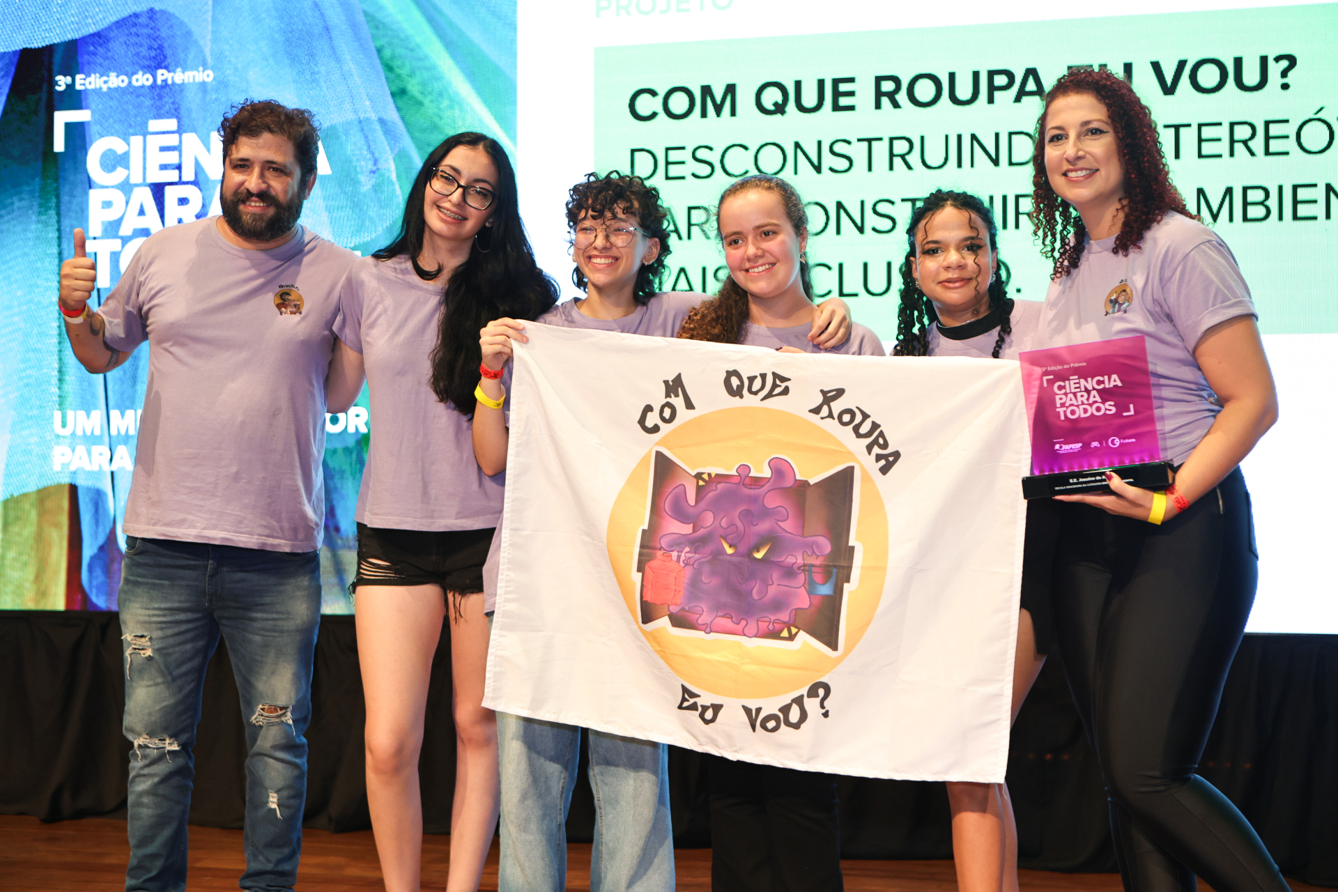 Seis pessoas de pé no palco.