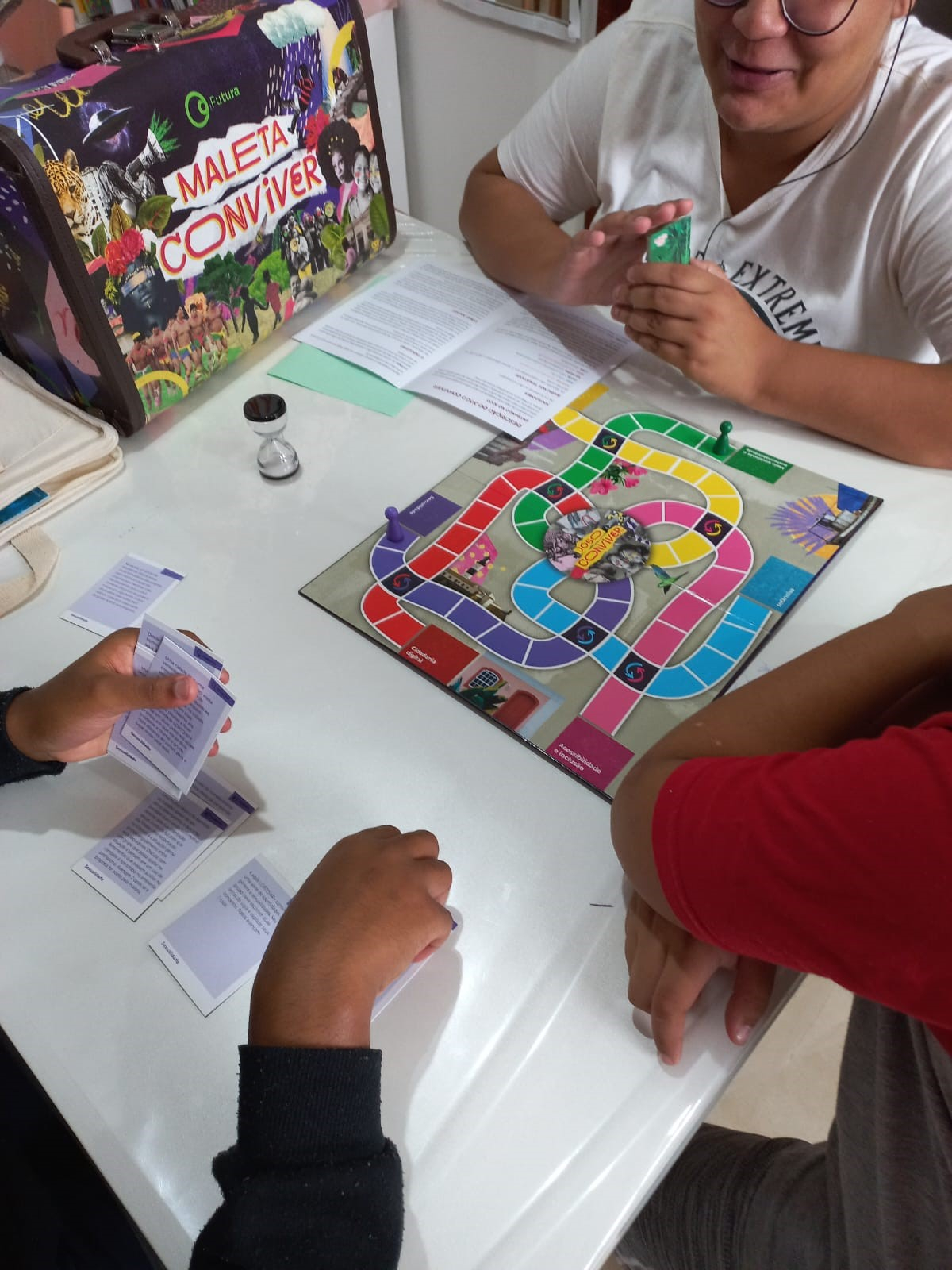 A imagem mostra crianças jogando um jogo de tabuleiro.