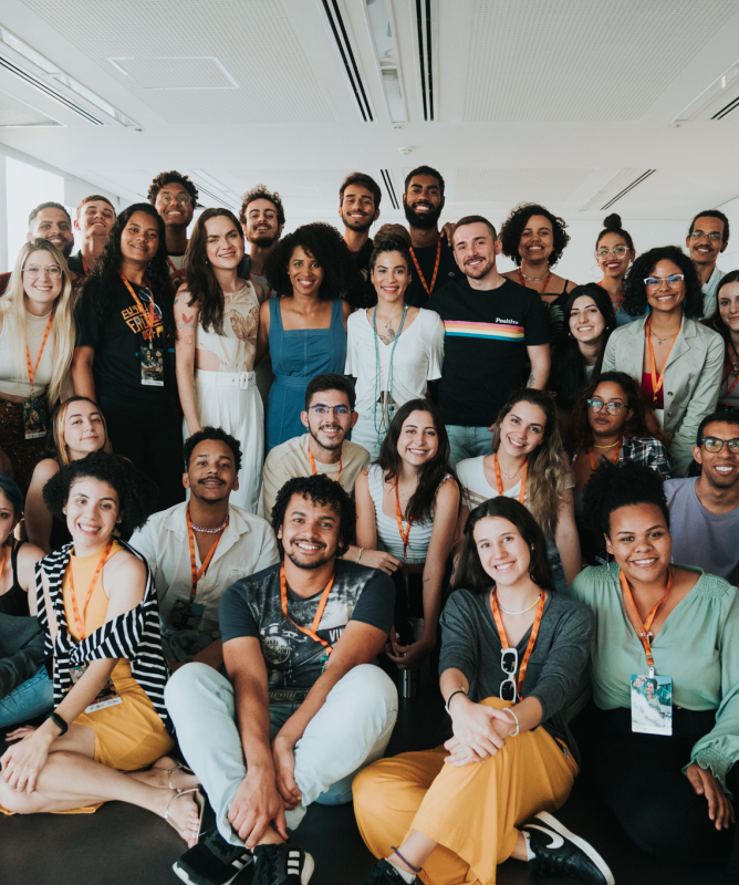 Um grupo com diversos estudantes posando para foto em uma sala de aula