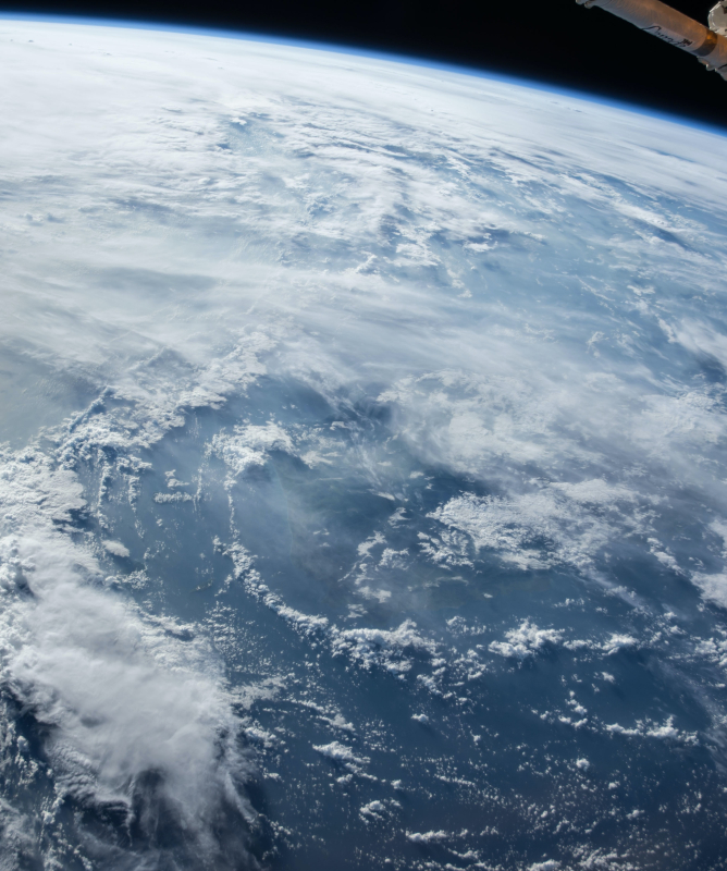 Imagem feita do universo mostrando um pedaço de um satélite da NASA e boa parte da atmosfera do planeta Terra