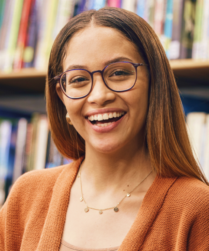Uma jovem está numa biblioteca e olha para foto