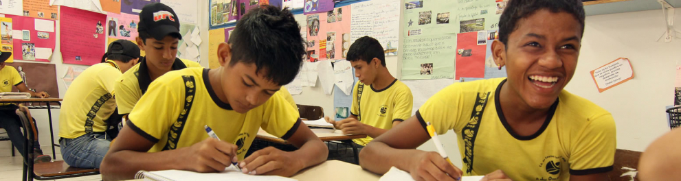 meninos em sala de aula escrevendo em seus cadernos