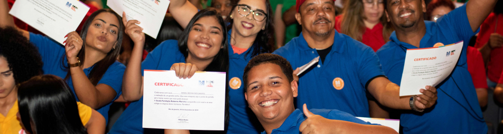 estudantes da escola da FRM levantando o diploma na cerimônia de formatura