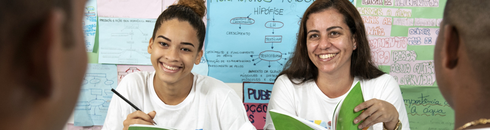 alunas em sala de aula segurando seus livros nas mãos